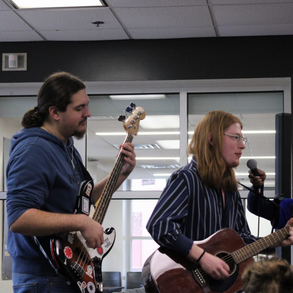 Two musicians in a band perform their music.