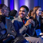 Photo of young men and women talking.
