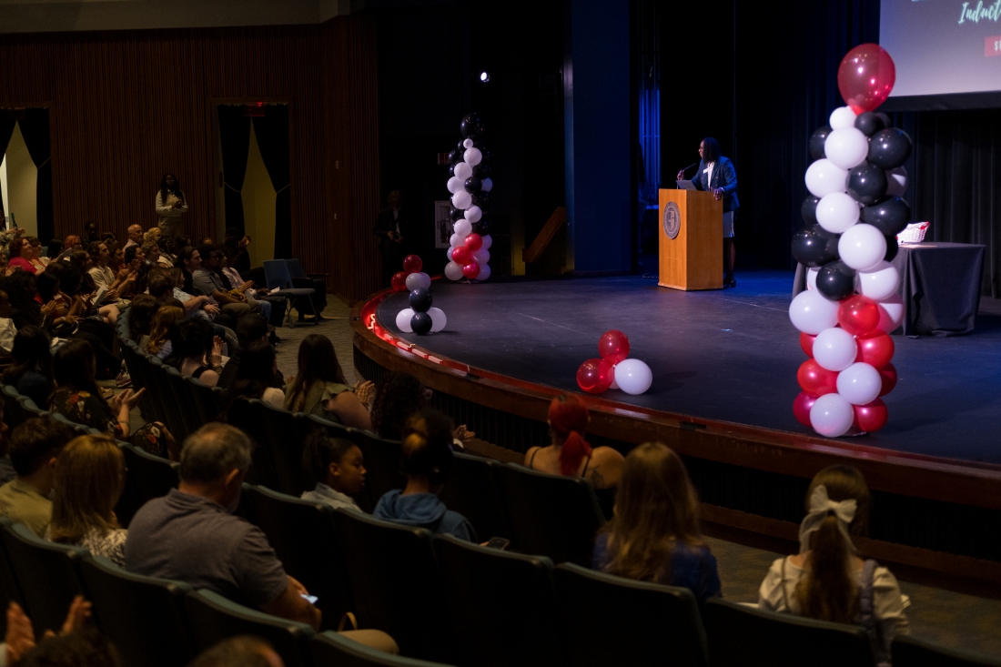 Black, white, and red balloons line the stage of the Clayton Performance Art center.