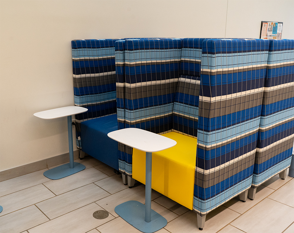 Two cushioned cubical seats accompanied by tables