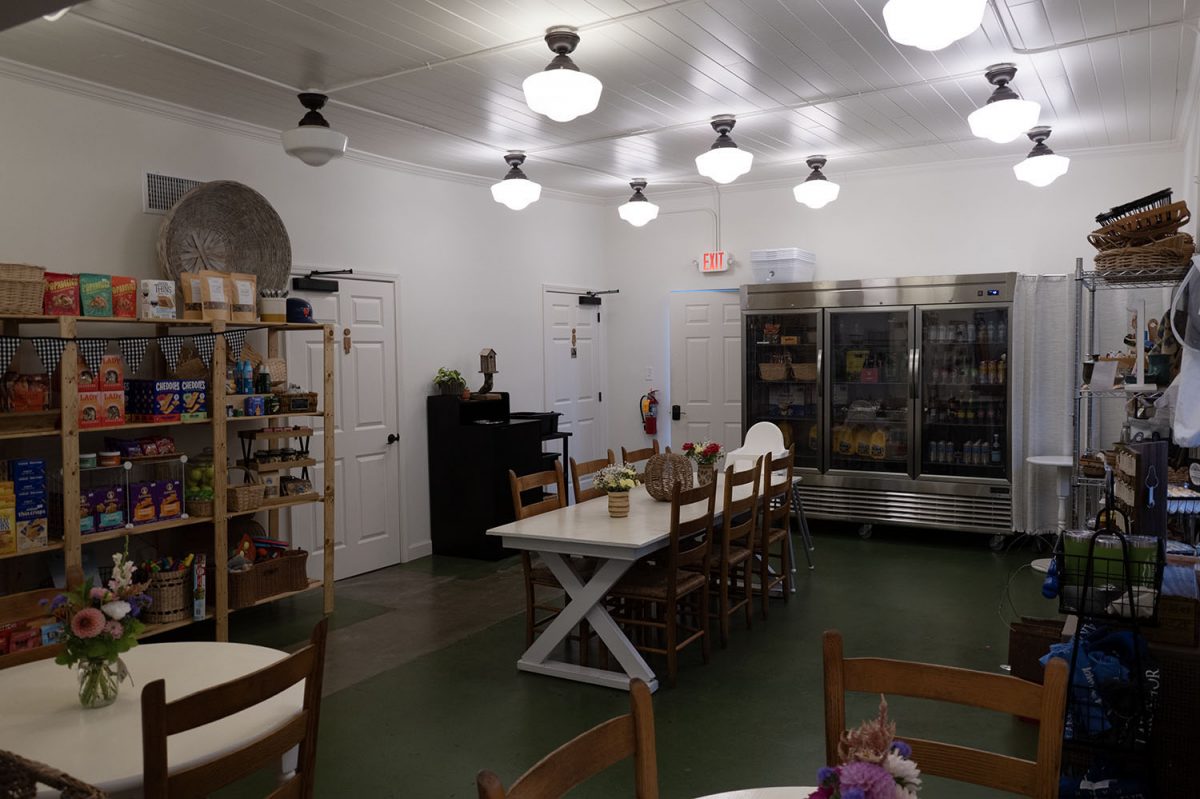 The market area inside of Camp Honey Coffee, with seating options and stands for all of the vendor