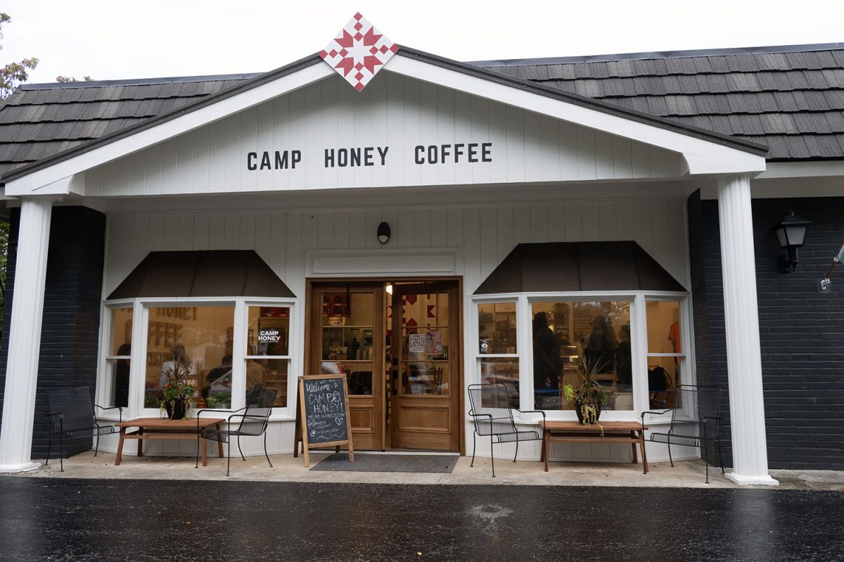 The storefront for a coffee house, with the guests sitting inside of it