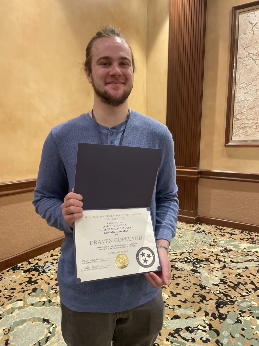 Editor-in-Chief Draven Copeland holding his award.