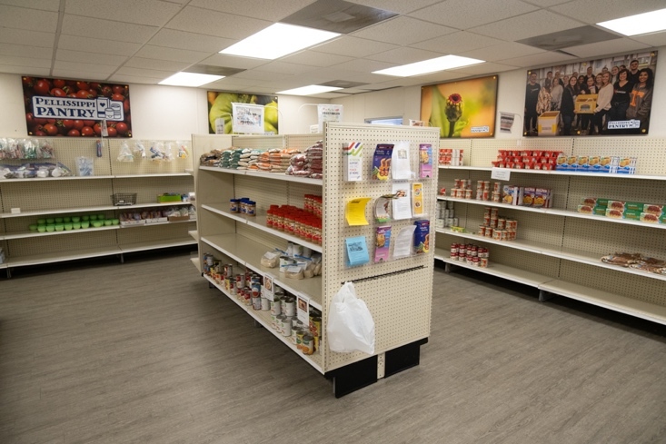 Shelves wrap around the room, with more shelves in the center of the room.