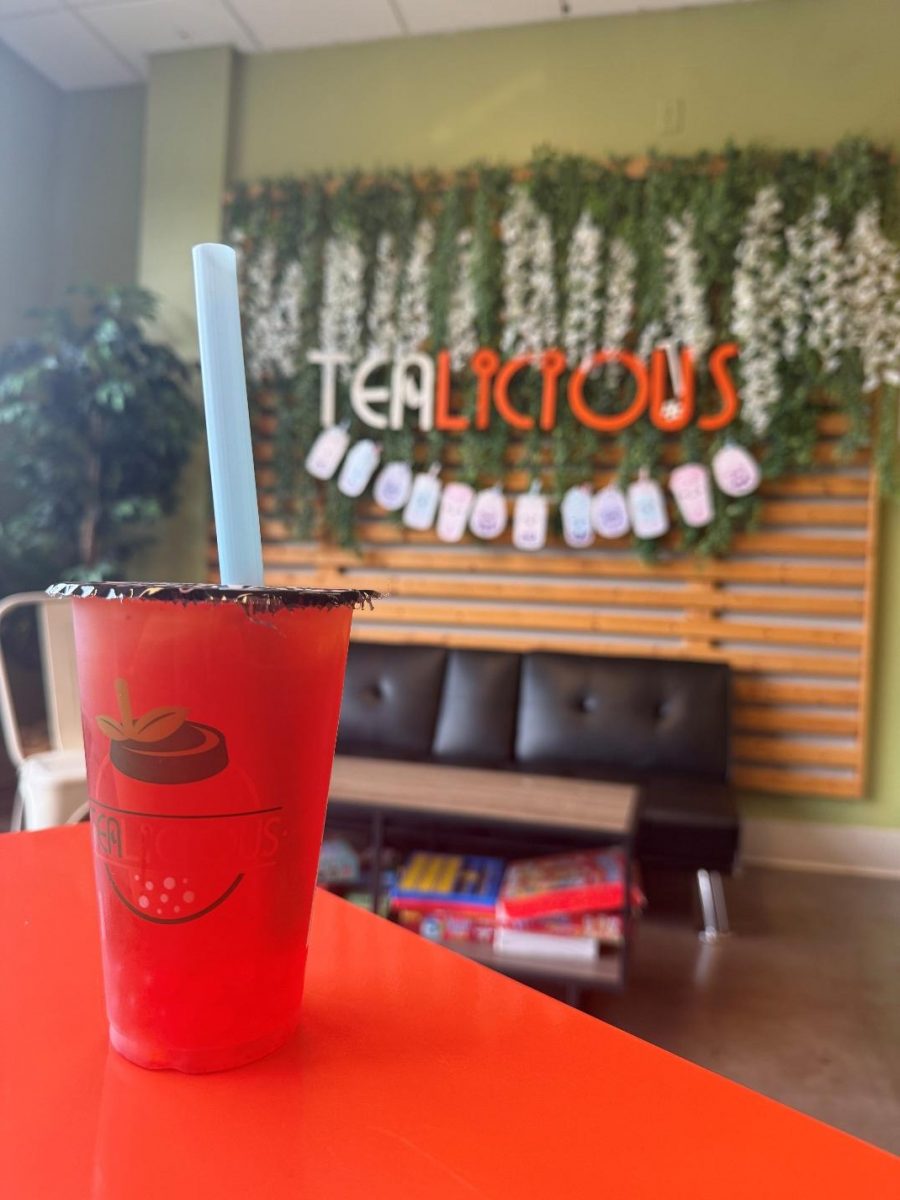 An Orange/Strawberry Fruit Tea on an orange table.