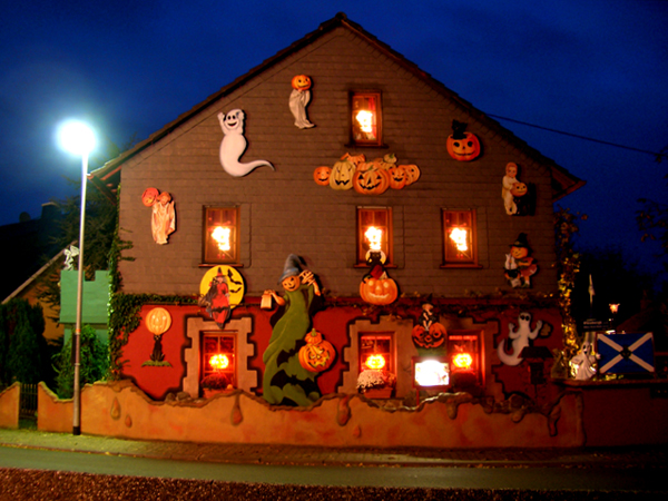 A house with various Halloween decorations on it.