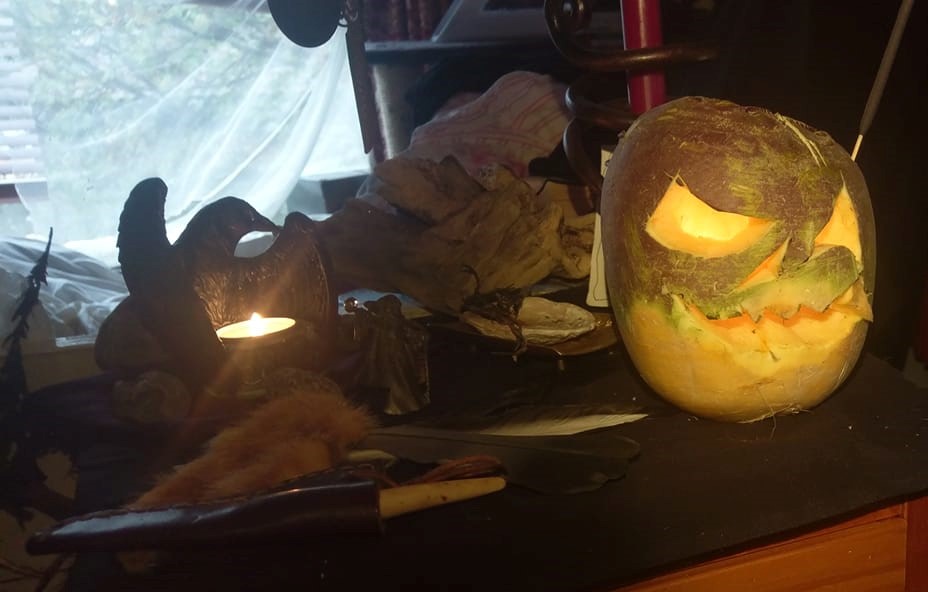 A turnip with a Jack-O-Lantern face carved into it on a table.