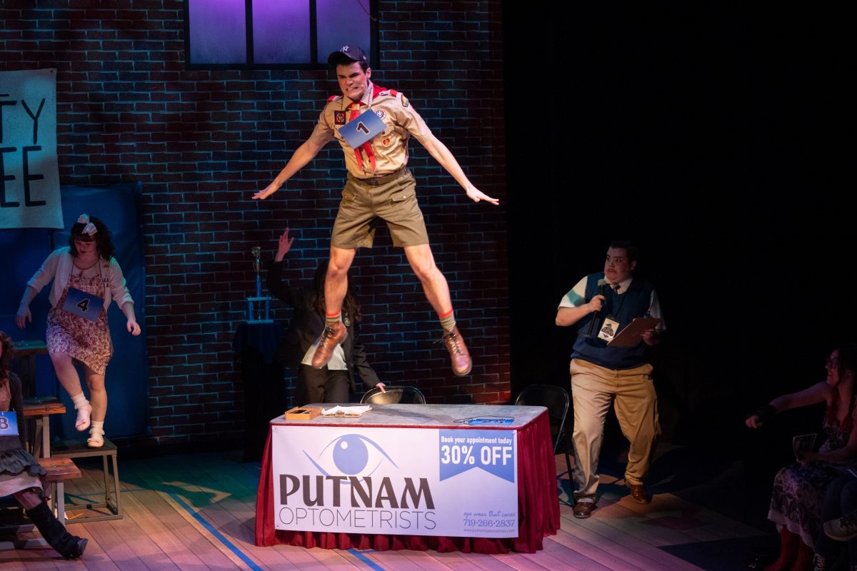 A man in mid-air bouncing off of a table, with stunned actors around him.