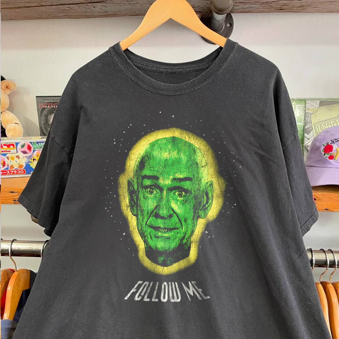 Marshall Applewhite "Follow Me" shirt on a clothes hanger.