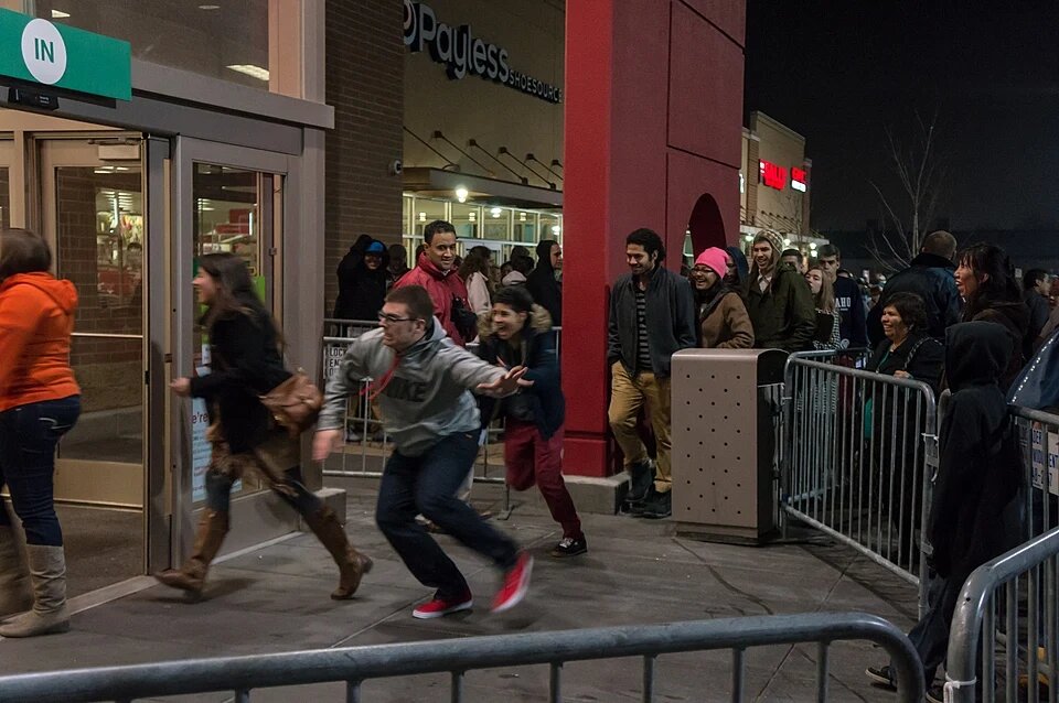 A queue outside of a Target with people running inside