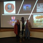 Professor Jeepers, or Grant Mincy with fellow professors posing in front of presentation