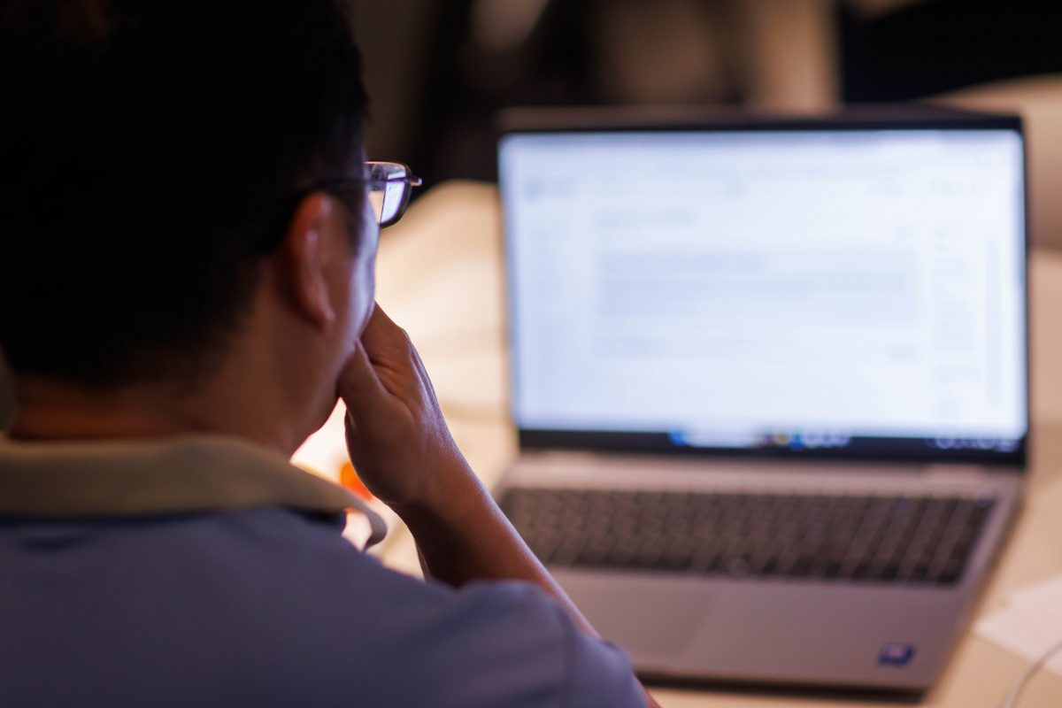 Person with glasses looking at a laptop