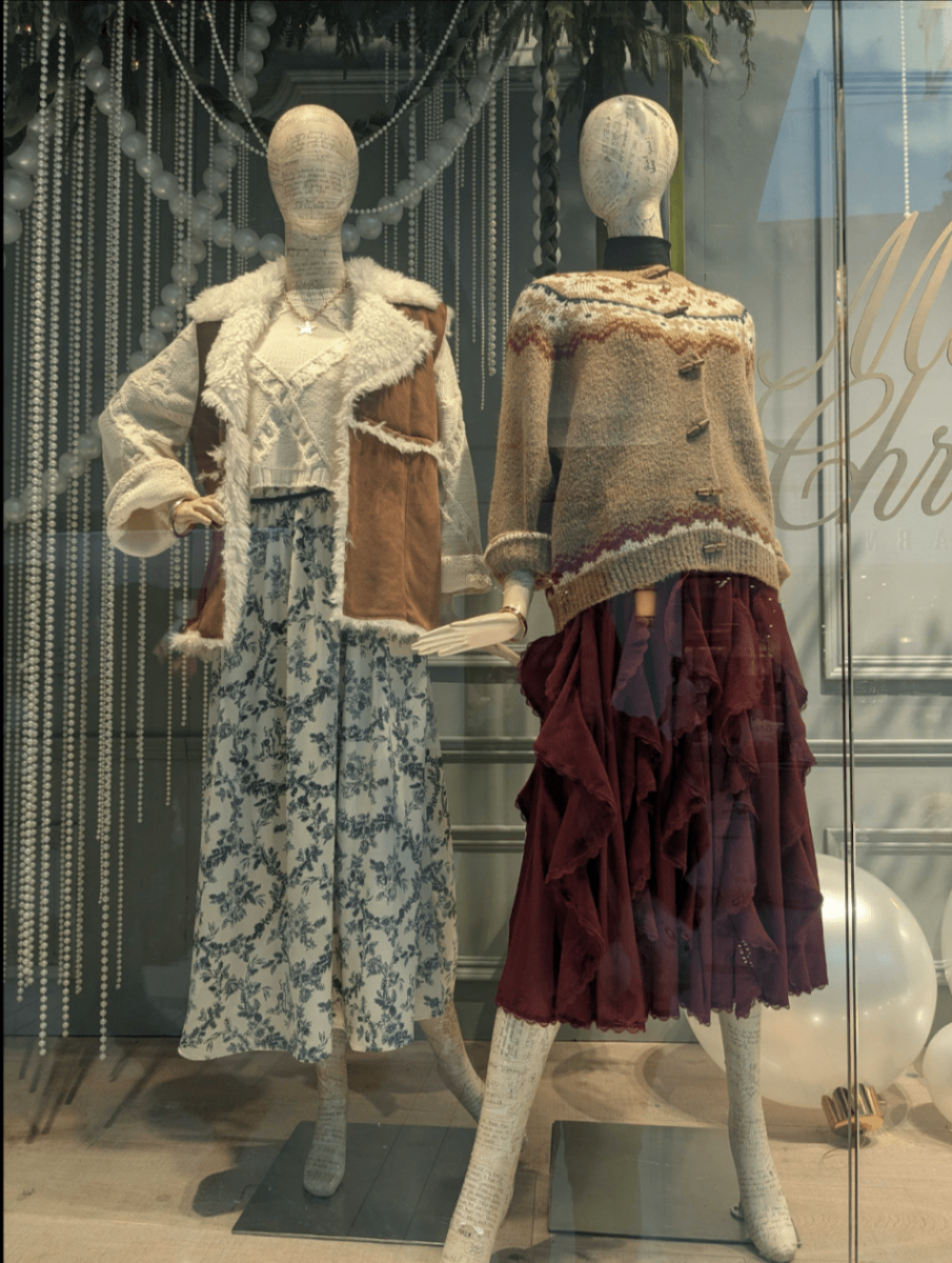 Two mannequins dressed in long skirts and layered outerwear shown in Altr’d States window display