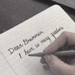 A hand holding a marker near notebook paper. The paper reads Dear Grammar, I have so many questions."