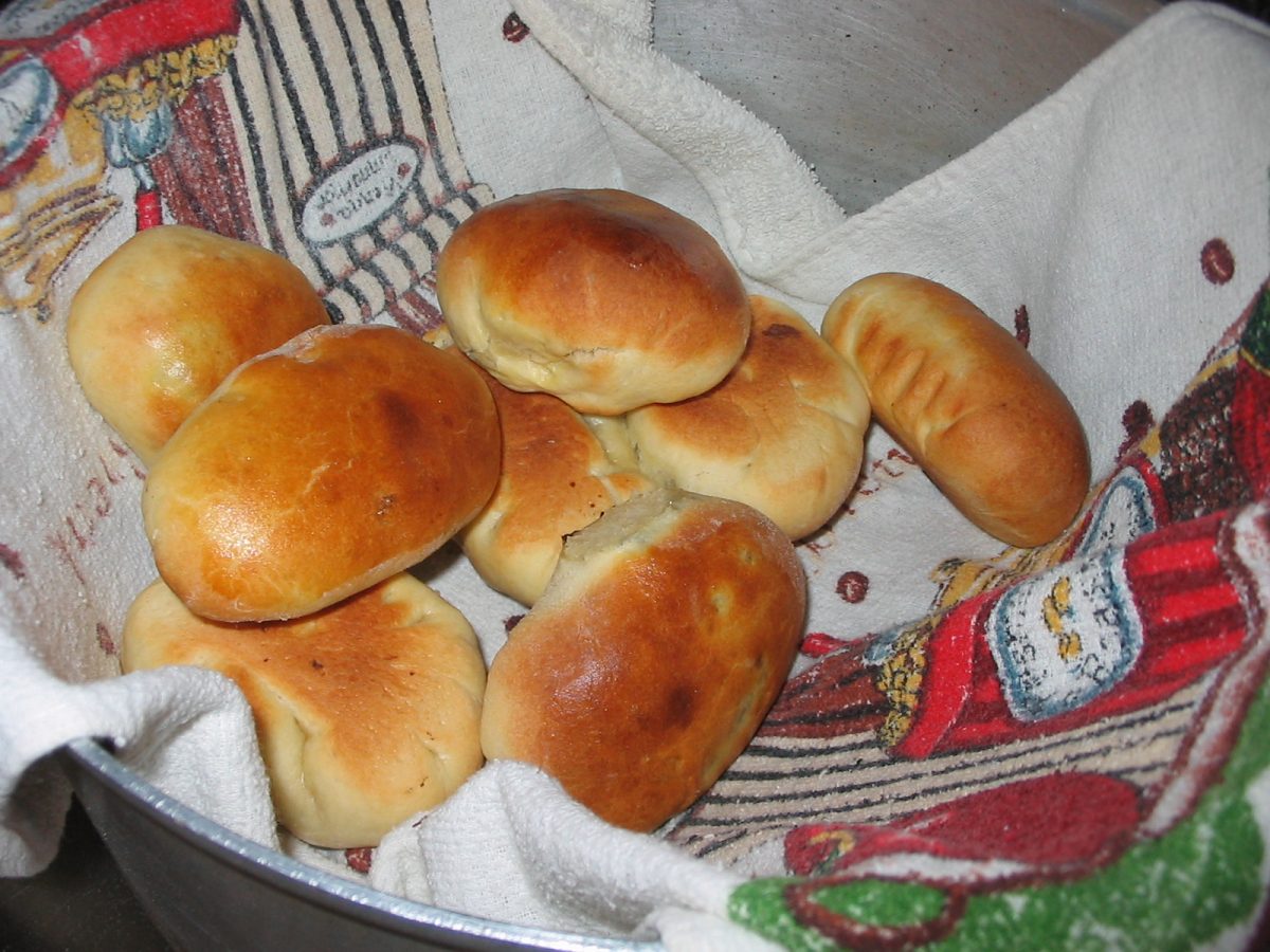 A bowl lined with a towel containing a batch of hand pies