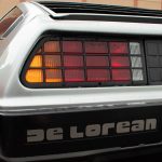 The DMC DeLorean's taillights. The bumper has text that reads "DeLorean".