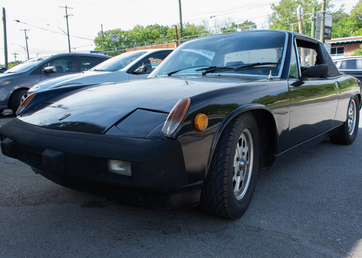 Porsche 914 parked next to two other cars.