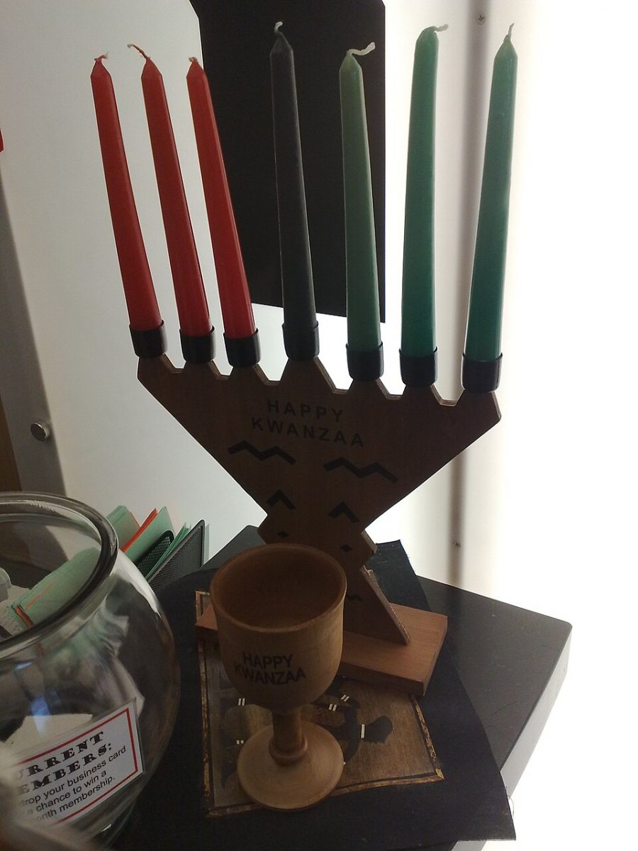 A kinara with seven candles, with the phrase “Happy Kwanzaa” printed on it.