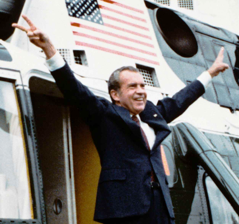 Richard Nixon waving at a crowd in front of Air Force One.