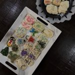 Various decorated sugar cookies in two plates. One plate is rectangular, and the other is circular.