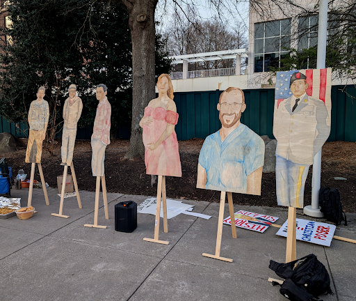 Pictured above are hand-drawn cardboard cutouts of people who have died under ICE custody: Renee Good, Alex Pretti, Geraldo Lunas Campos, among others.
