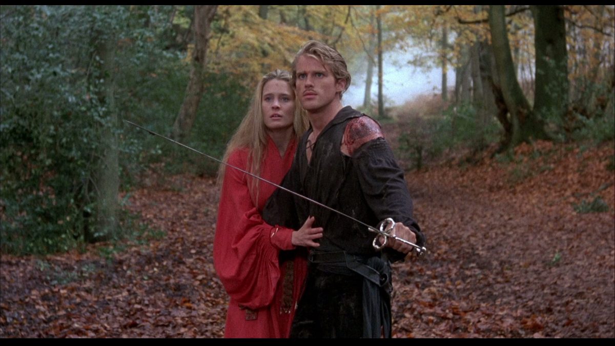 Buttercup and Westley exiting the fire swamp. Westley holds a sword as Buttercup holds on to him.