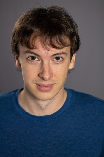 White man with brown hair and eyes looking directly at camera.