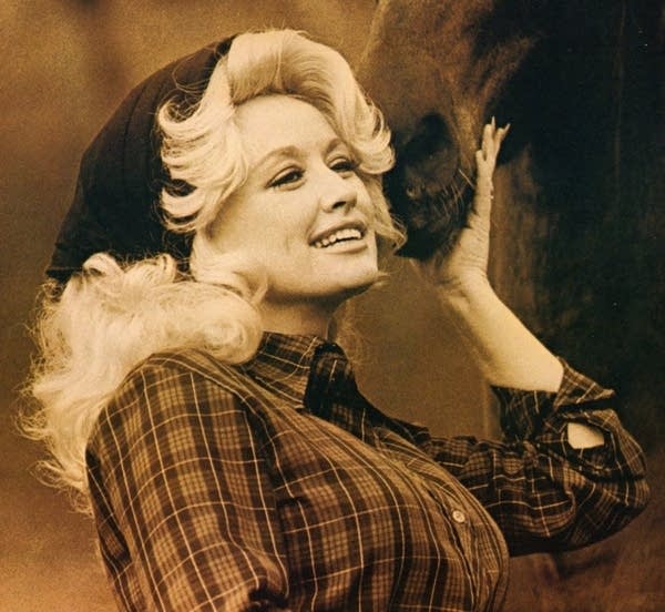 Dolly Parton and a horse smiling for a picture
