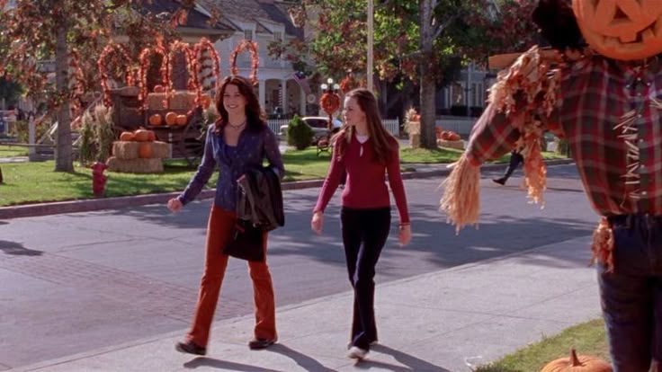 Two girls walking in the small town dressed in fall, 2000s clothes